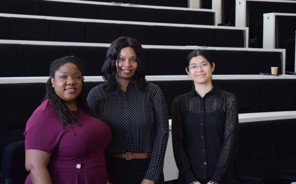 Image of 3 women dressed professionally in a lecture theatre and smiling
