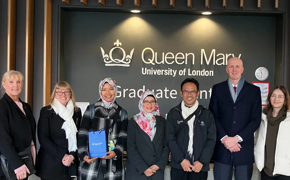 A group of people standing in the graduate centre at Queen Mary University of London.  A mix of male and female all smiling.
