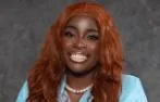 Iyanujesu Oguntunji smiling. She is wearing pearls and a baby blue top.