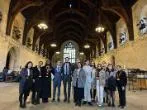 Group of Queen Mary LLM students stood in House of Lords smiling at camera.