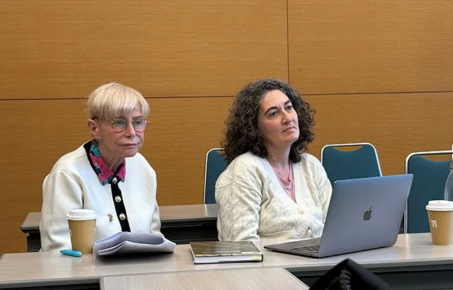 Malgosia sits at a desk beside a lady with dark hair.