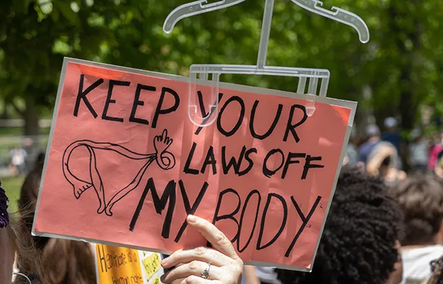 Someone holding up a sign at a protest that says 