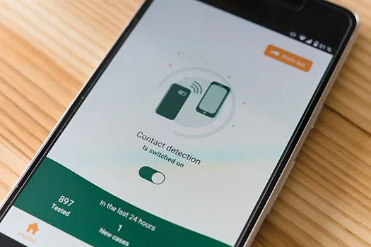 Smartphone on a table with a contact tracing app enabled to detect coronavirus transmission