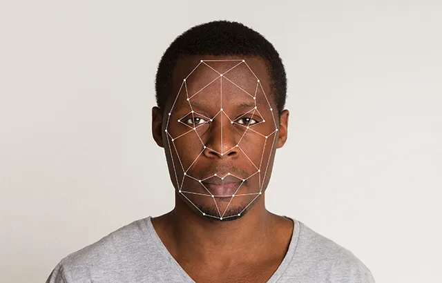 A black man facing the camera. He has dots across his face indicating his face is being scanned.