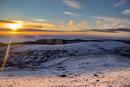 A sunrise over a snowy landscape on the Isle of Man