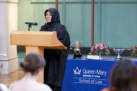 Student in a headscarf standing at a podium during the 2022 George Hinde Moot.