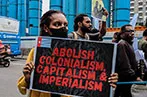A woman at a rally holding a placard that says 