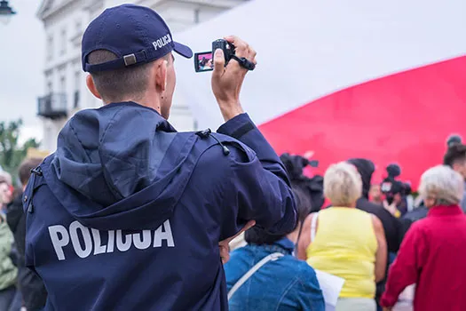 A police officer holding a video camera recording