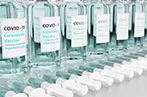 A row of Covid-19 vaccine vials with syringes