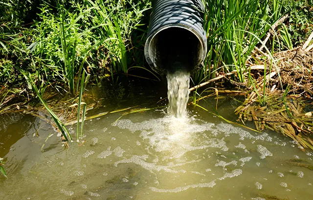 Sewage pipe discharges sewage and wastewater into the river.