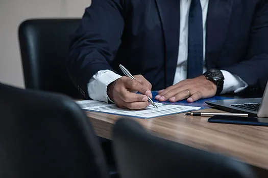 A solicitor sat at a table writing on a document