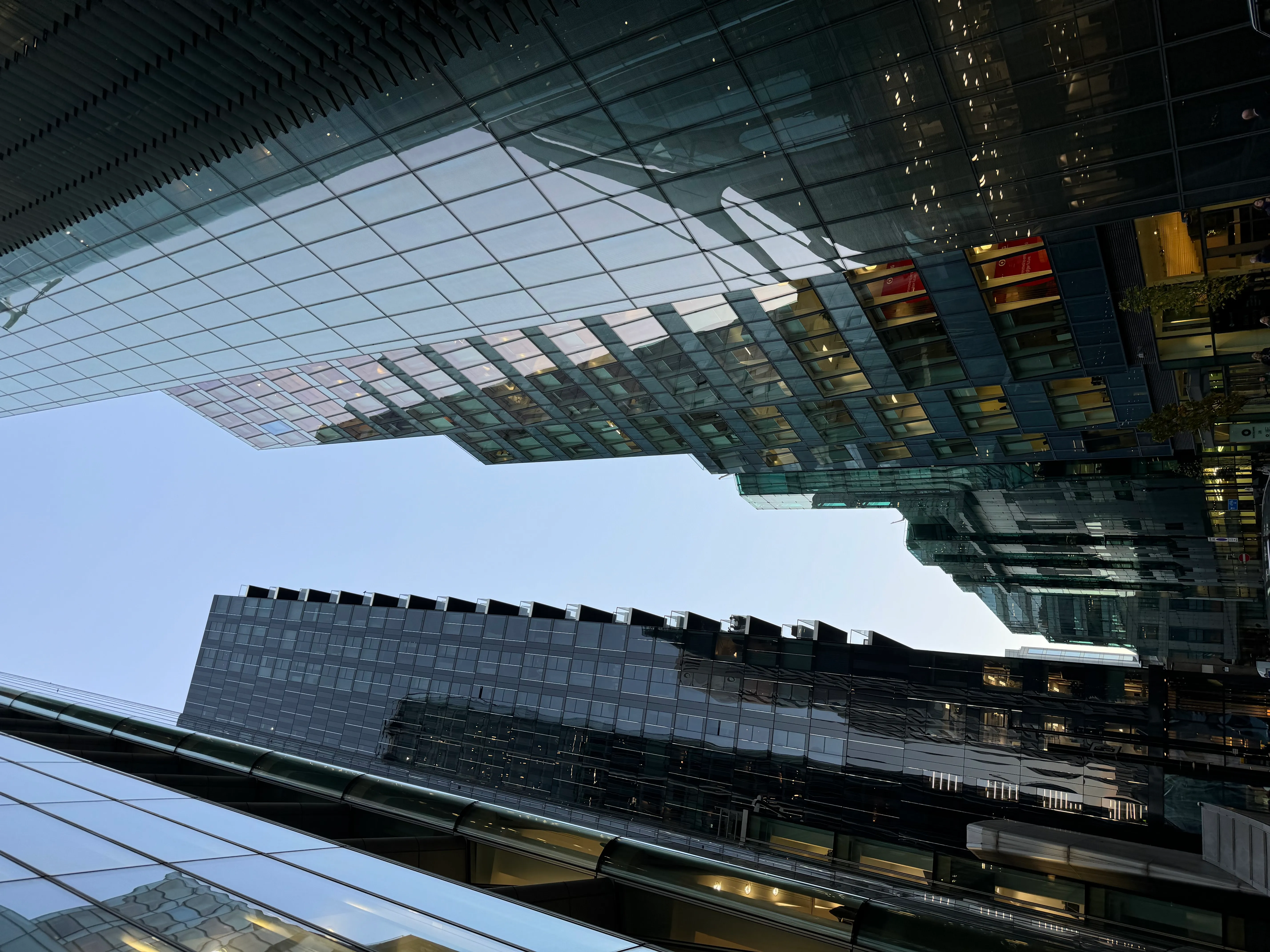 Looking up at high-rise glass buildings from the street.