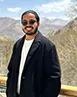 Philip Denny Mathew standing in front of mountains.