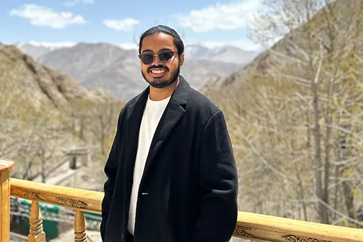 Philip Denny Mathew standing in front of mountains.