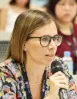 Woman holding a microphone and speaking at a conference