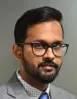 Asian man with beard and glasses in grey suit