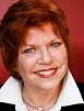 Prof Anne Flanagan in white shirt in front of red background