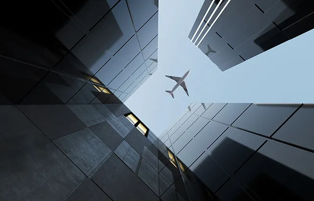 A plane passing over some office buildings.