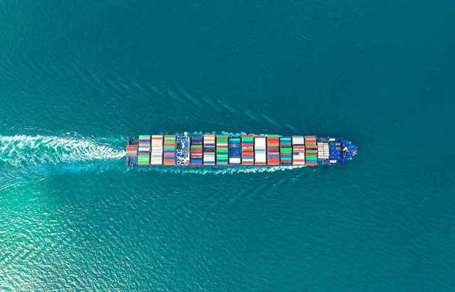 A boat with shipping contains sailing through the ocean.