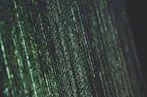 Vertical green lines of code across a whole laptop screen.