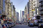 Buenos Aires street lined with cars and obelisk in the background