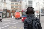 Person wearing headphones crossing the street