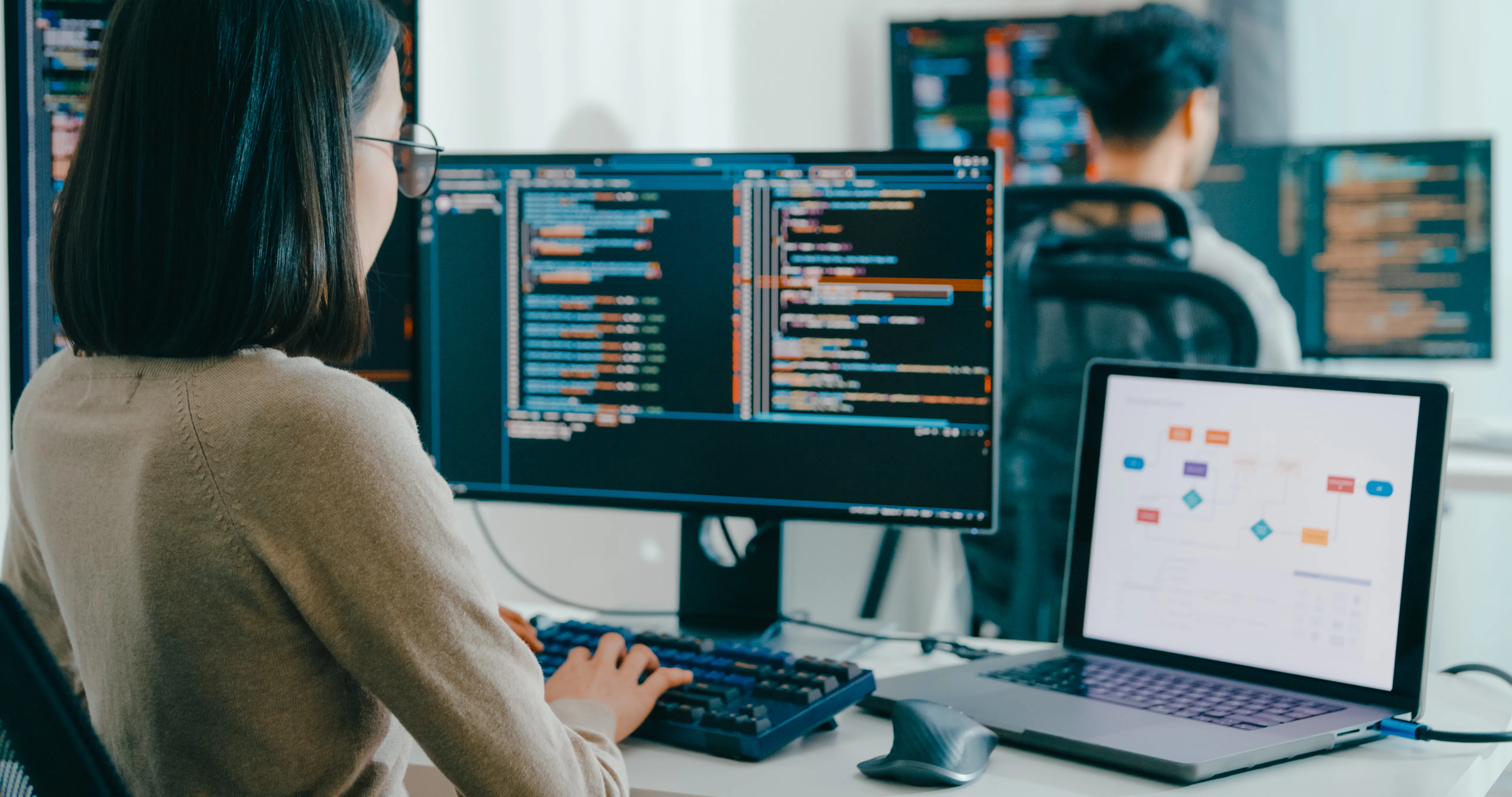 Female student writing code on a PC