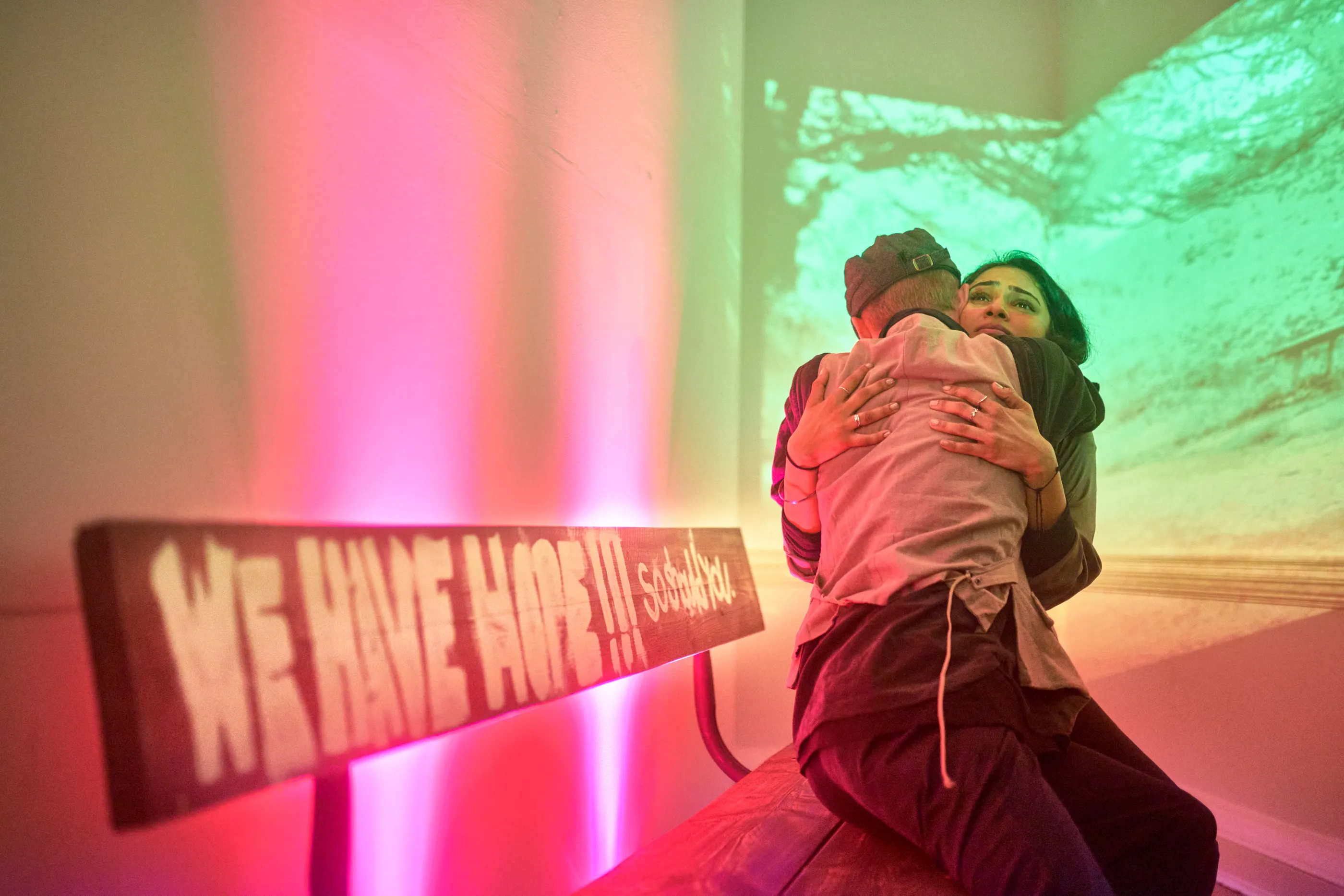 Two people hugging on a bench
