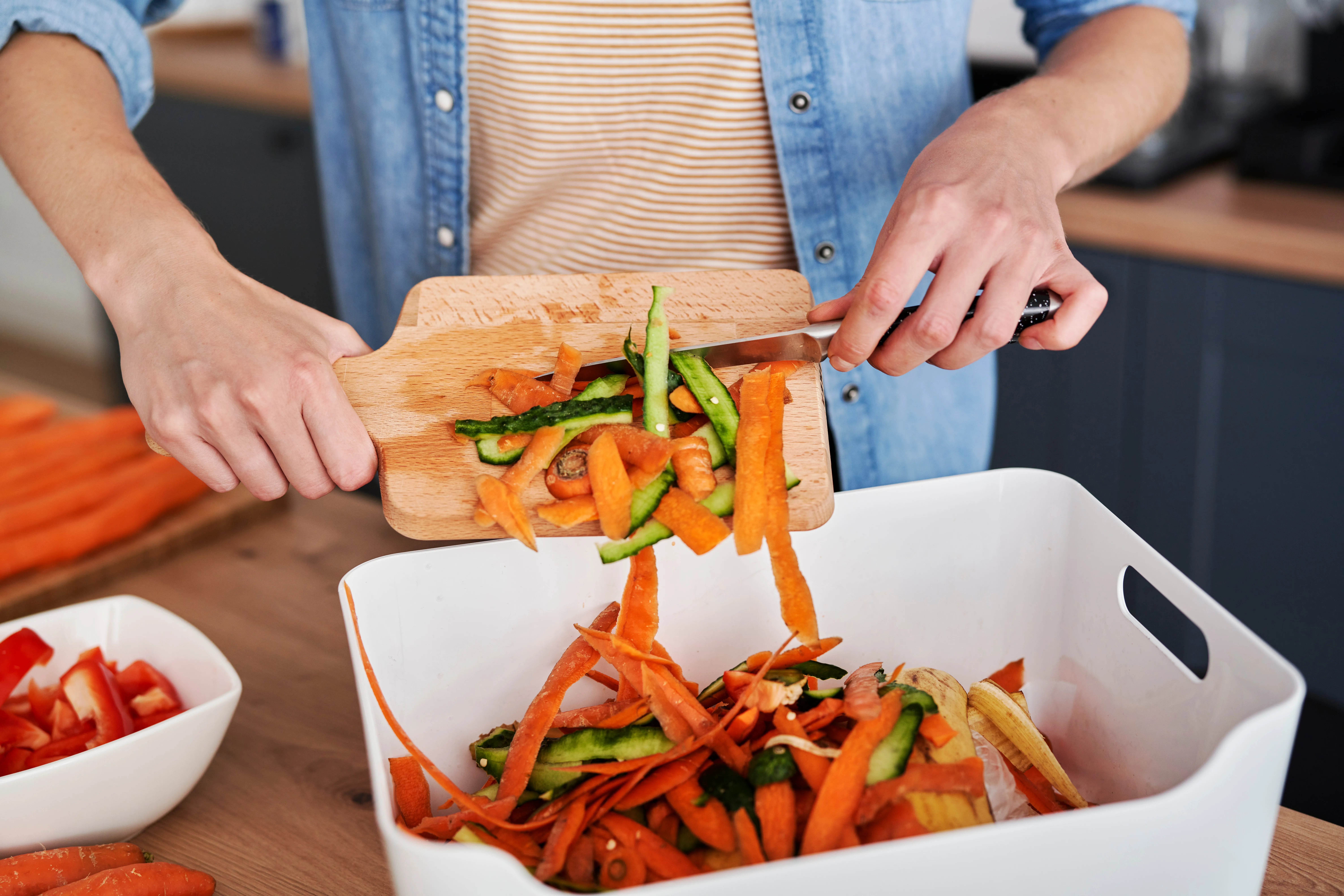A man scraping food waste into a bin