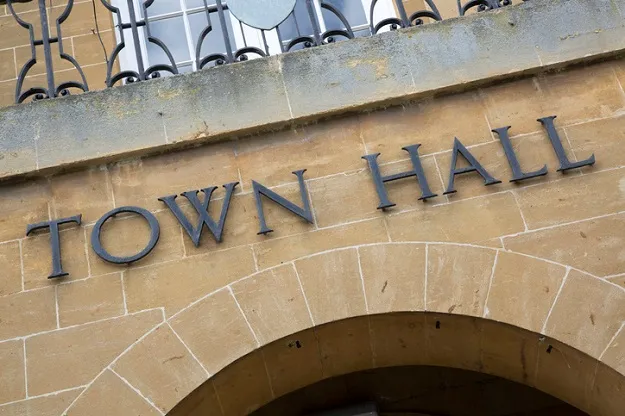 Photo of a sign saying 'Town Hall' on a brick building. Location unknown.