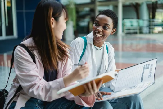 Two female students sat together talking