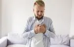 A man holding his chest in discomfort