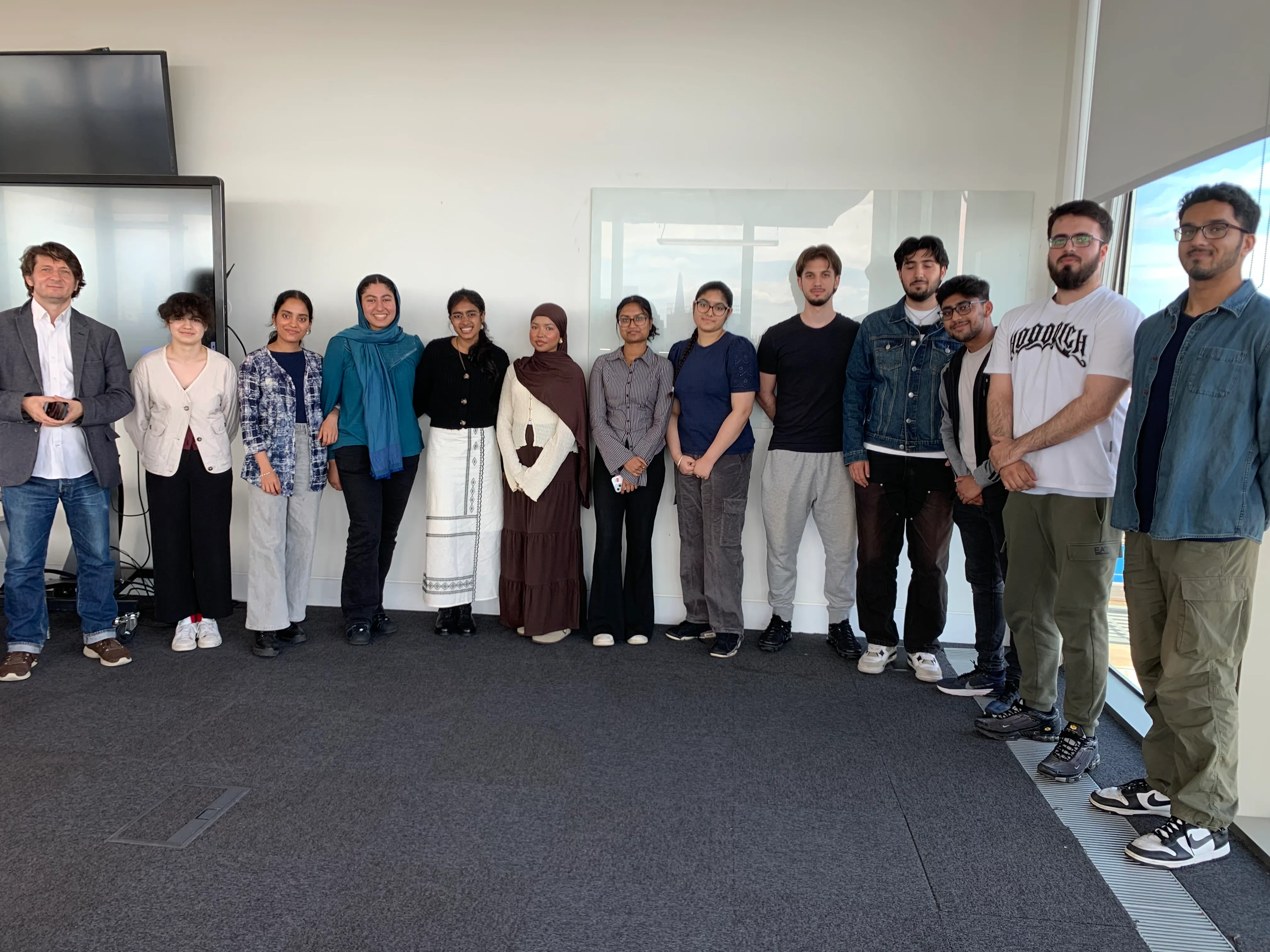 A group of students and academics facing the camera smiling