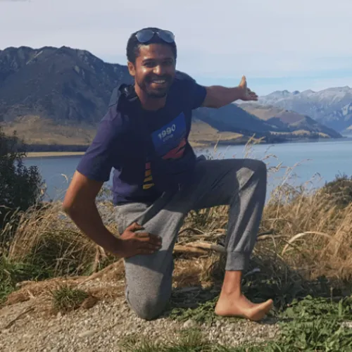 Terence pictured in front of mountains and a lake on his travels