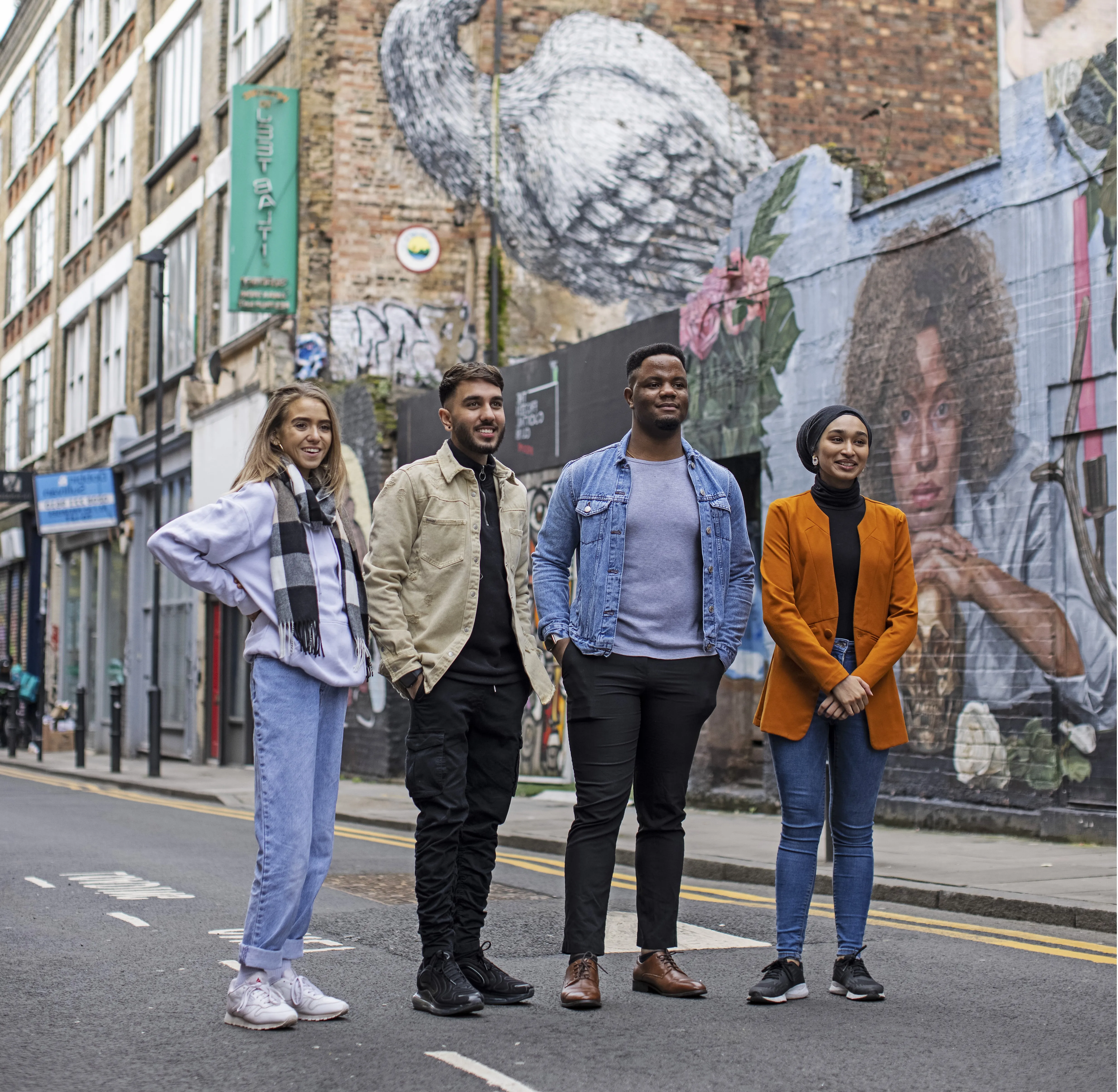 Students standing in front of graffiti wall.