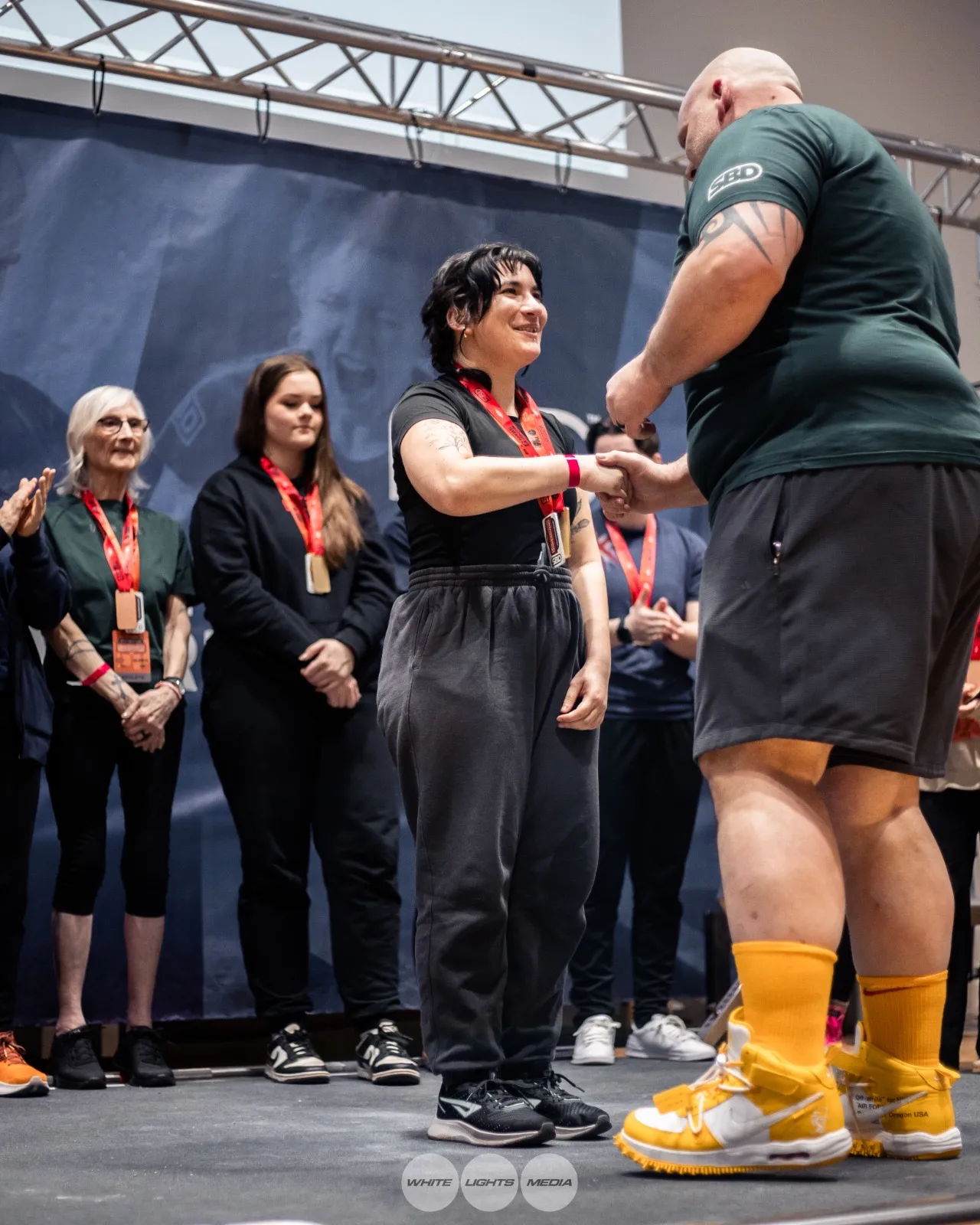 Sara shaking hands as she receives her medal