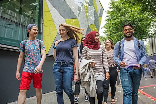 A group of 4 students walking towards the camera