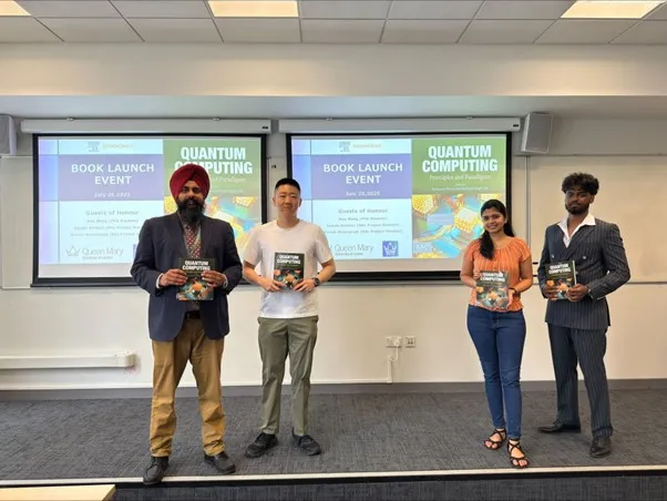 4 people on a stage holding a book at launch