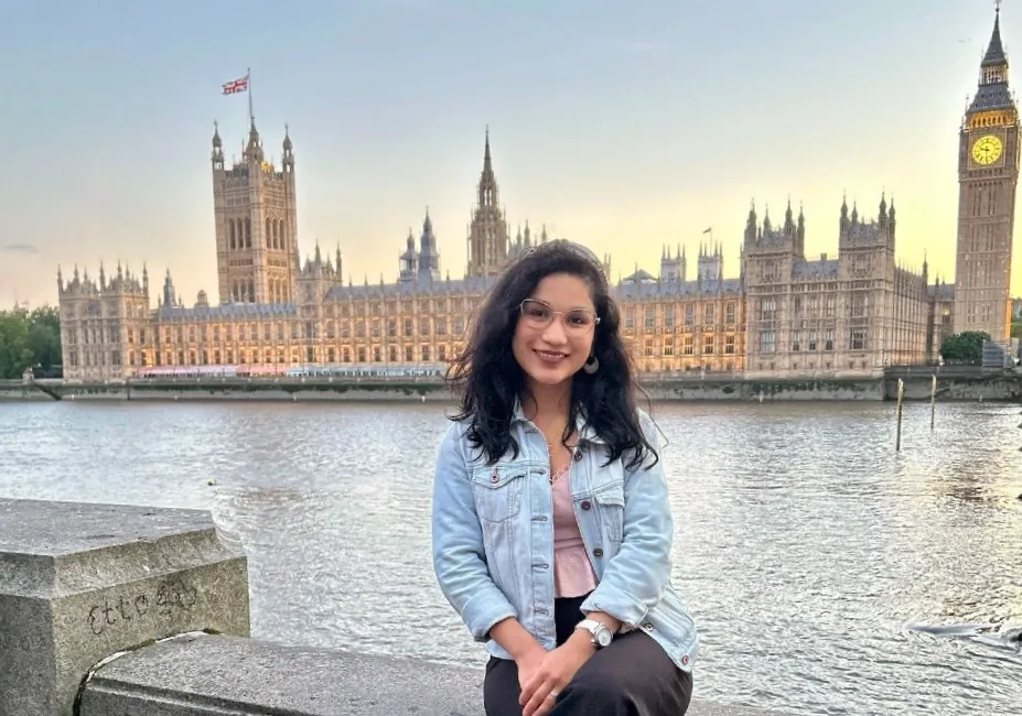Girl sitting in front of the River Thames and Big Ben