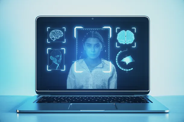 Laptop with person on the screen, their face being scanned