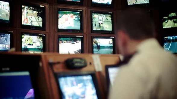 A CCTV operator in front of a series of screens monitoring Birmingham city centre