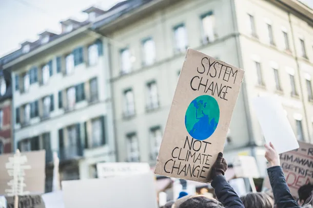 Placard being held up in protest that reads SYSTEM CHANGE NOT CLIMATE CHANGE