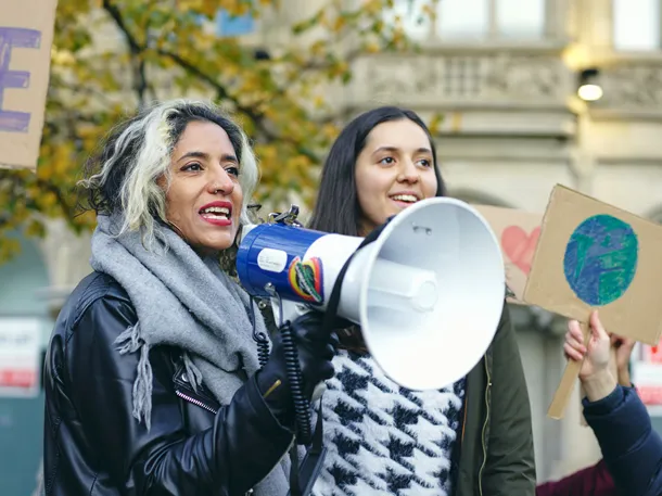 Two protesters holding placards and a loudspeaker