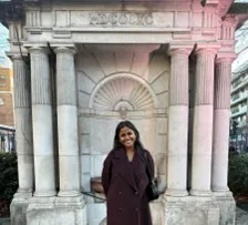 Tushitta Murali standing in front of an ornate water fountain.