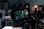 Idan Gal-Shohet being filmed on a camera. He is standing in a laboratory surrounded by people in lab coats.