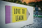 A sign on a university campus saying 'love to learn'
