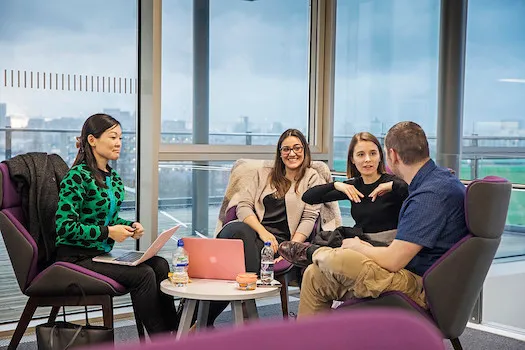 Four postgraduate students talking in the Graduate Centre