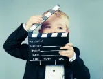 Photograph of a child with clapperboard