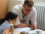 A girl has her lung capacity measured by researcher (2018)