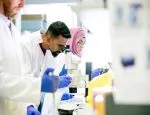 Person in scientific research lab looks into microscope